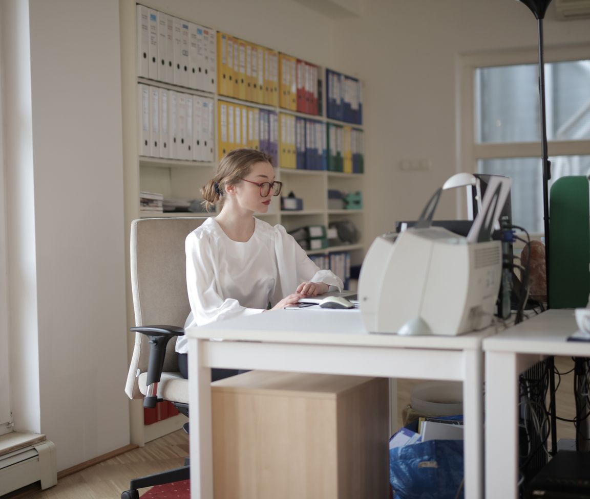 Pic of an office manager working at a computer desk with organized binders