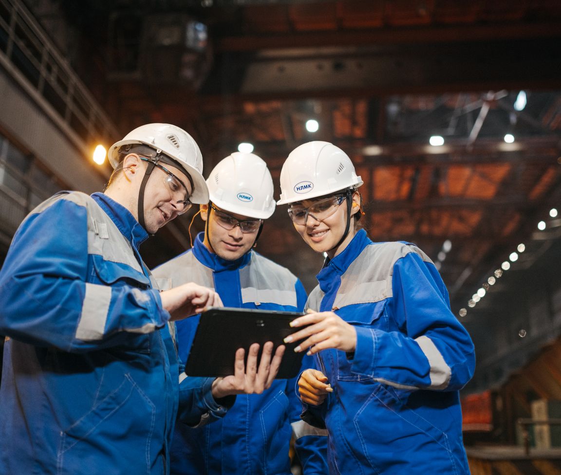 Pic of an engineering manager reviewing a project on a tablet with two team members