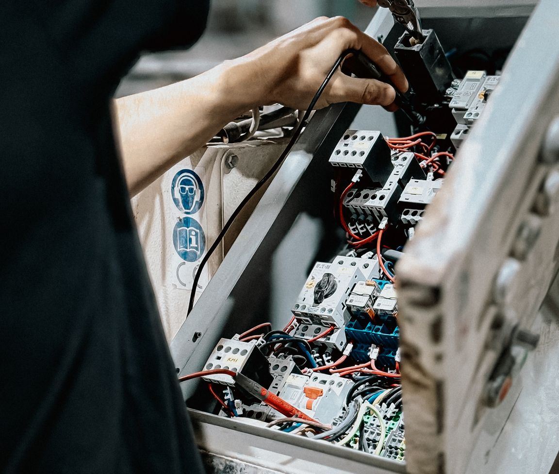 Pic of a panel technician wiring components inside an automation panel